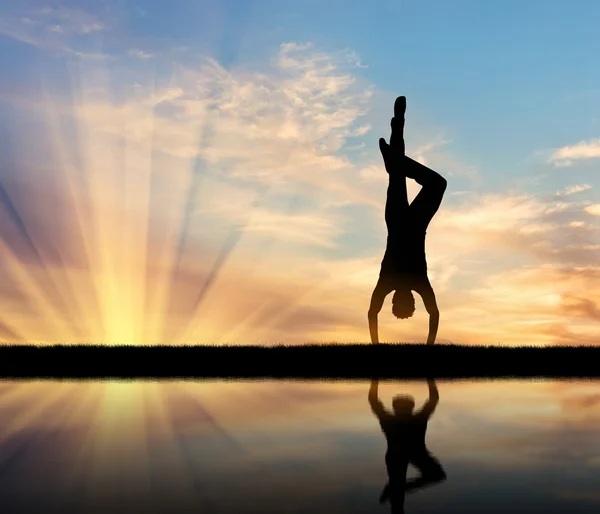 Silhouette of a man practicing yoga — Stock Photo, Image