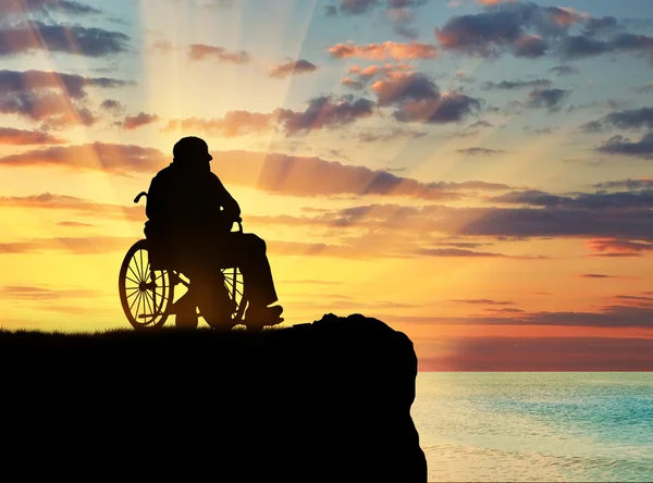 Silhueta de pessoa com deficiência em uma cadeira de rodas — Fotografia de Stock
