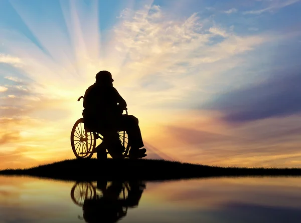 Σιλουέτα του άτομο με ειδικές ανάγκες σε ένα wheelchai — Φωτογραφία Αρχείου