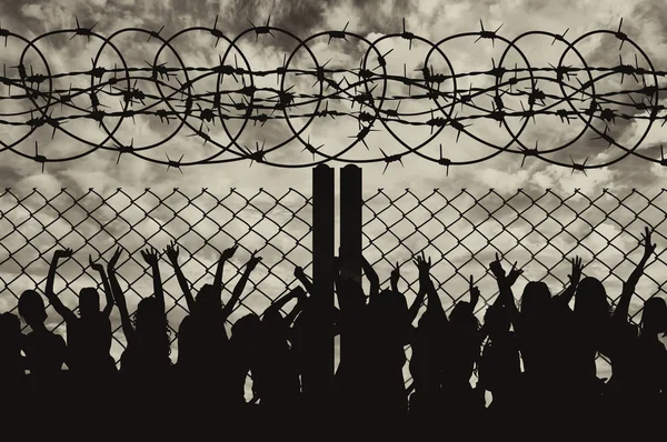 Silhouette of refugees and barbed wire — Stock Photo, Image