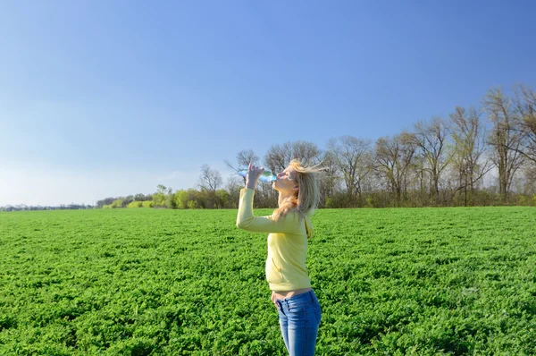  Genç kadın rahatlatıcı bir plastik şişe suyu içer