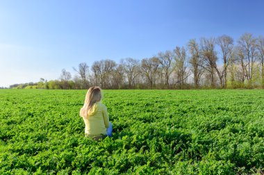 Genç kadın çayırda yeşil çimenlerin üzerinde dinlenme