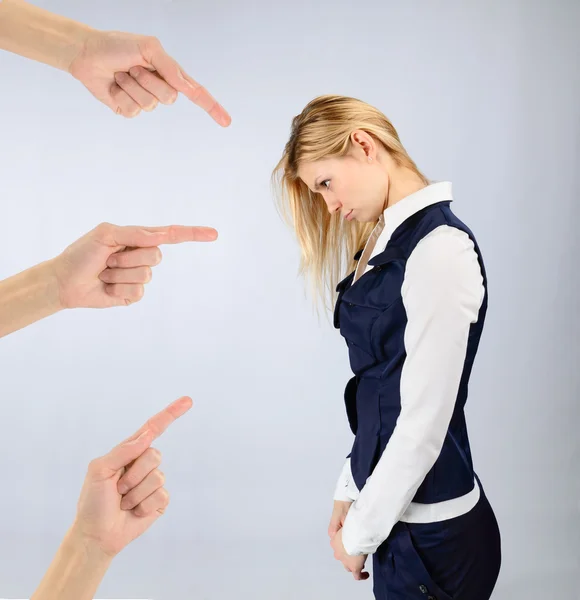 Sad girl in a suit and hands pointing at it — Stock Photo, Image