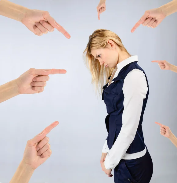 Sad girl in a suit and hands pointing at it — Stock Photo, Image