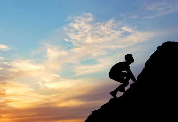 Silhouette purposeful man rising to the top of the mountain without insurance — Stock Photo, Image