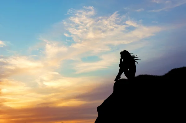 Silhouet van een vrouw die alleen op een heuvel bij zonsondergang — Stockfoto