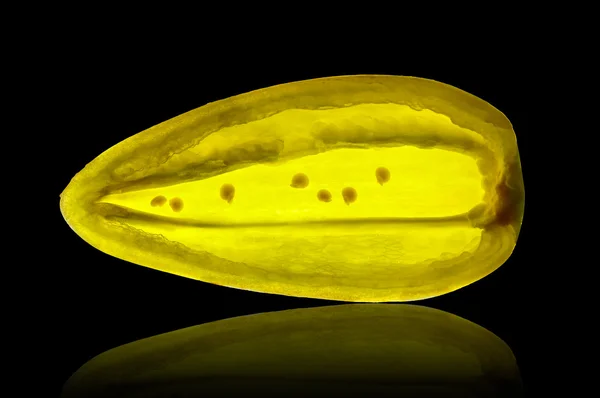 Segment van gele peper geïsoleerd op een backlit zwarte achtergrond — Stockfoto