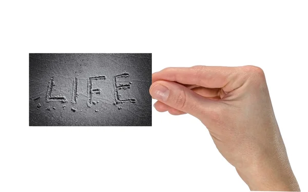 Mano con una tarjeta de visita donde se escribe la palabra de vida — Foto de Stock