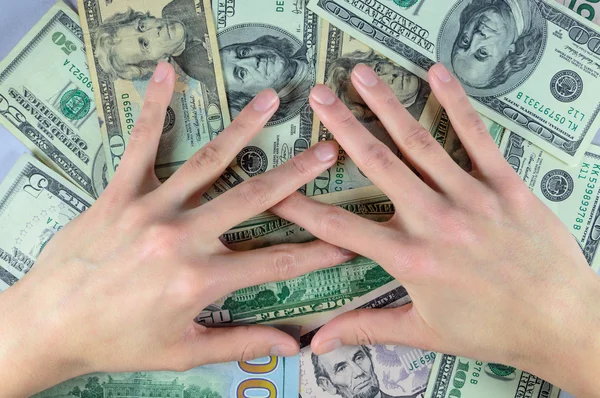 Manos humanas en una pila de dinero de dólares — Foto de Stock