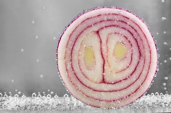 Cut red onions in water — Stock Photo, Image