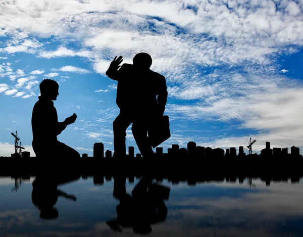 Silhouette of the rich and the poor man on the background cityscape — Stock Photo, Image