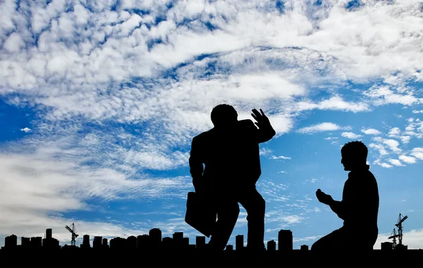 Silhouet van de rijke en de arme man op de achtergrond stadsgezicht — Stockfoto