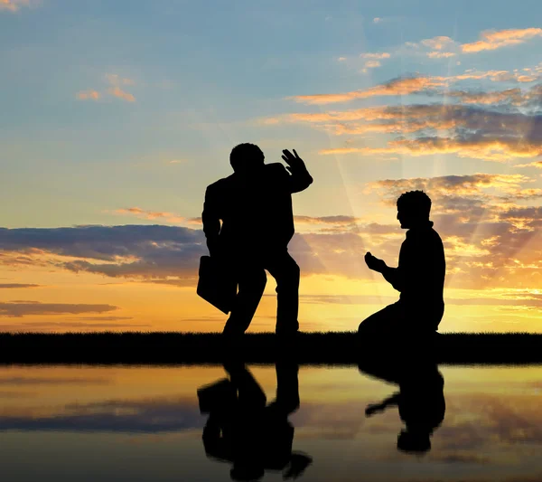 Silueta de los ricos y el pobre hombre al atardecer — Foto de Stock