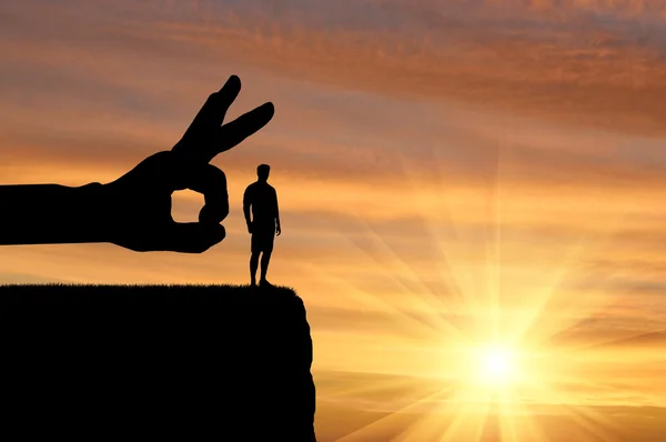 Silhouette hand wants to push a man off a cliff — Stock Photo, Image