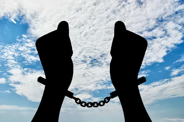 Silhouette of human hands in handcuffs — Stock Photo, Image