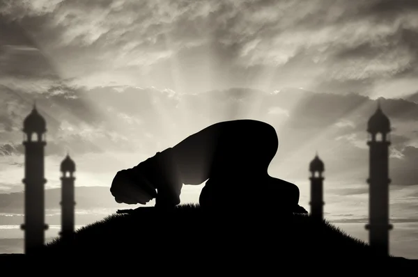 Muçulmano reza ao pôr do sol perto da mesquita — Fotografia de Stock