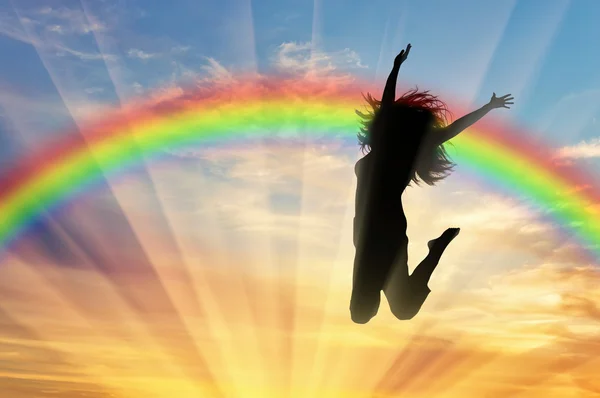 Glückliche Frau springt in der Nähe des Regenbogens — Stockfoto