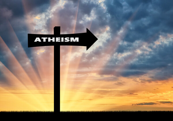 Road sign of atheism at sunset