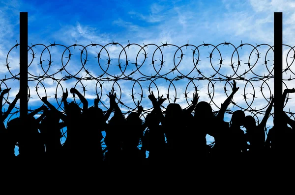 Silhouette of refugees and barbed wire — Stock Photo, Image