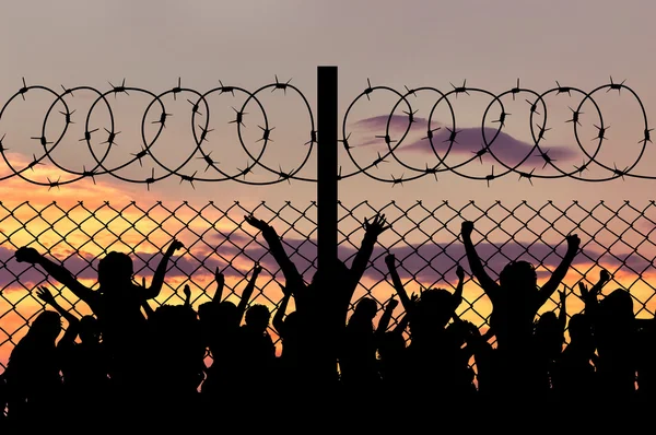 Silhouette mülteciler ve dikenli tel