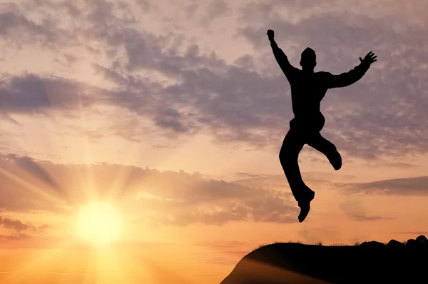 Silhouette of a man jumping in the sunset — Stock Photo, Image