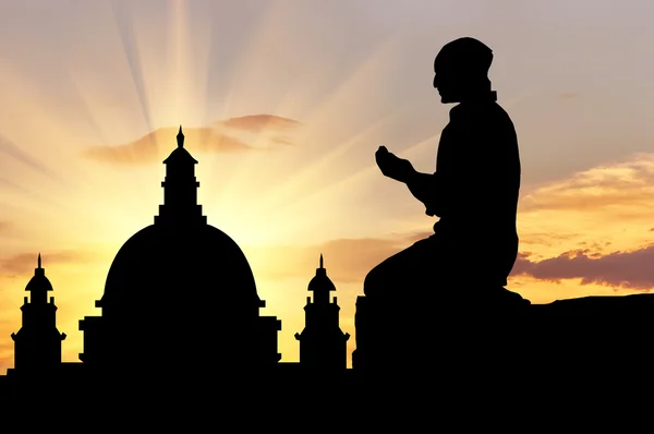 Silhouette of man praying at sunset — Stock Photo, Image