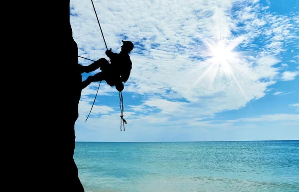 Silhouette alpiniste escalade une montagne — Photo