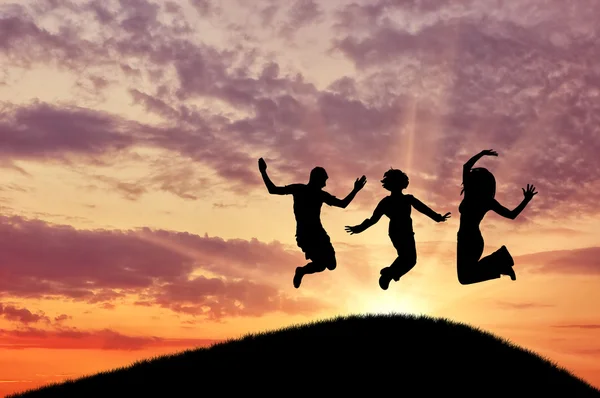 Силует щасливої групи людей стрибає — стокове фото