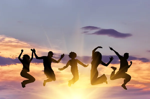 Силует щасливої групи людей стрибає — стокове фото