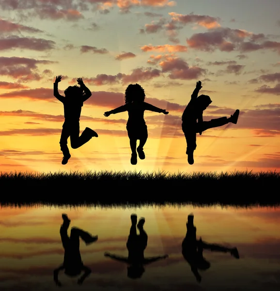 Силует щасливі діти стрибають — стокове фото