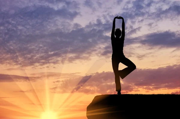 Silhouette of a girl practicing yoga — Stock Photo, Image