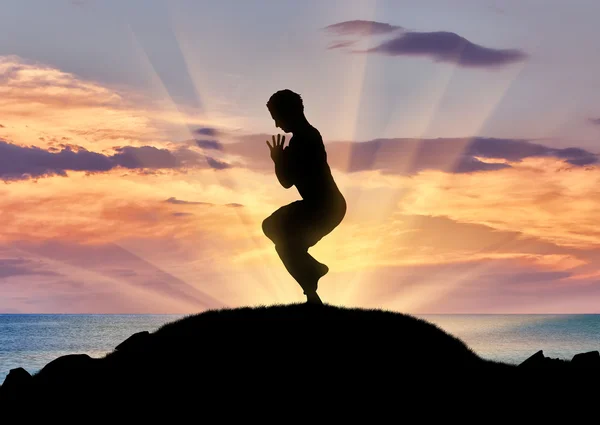 Silhouette of a man practicing yoga — Stock Photo, Image