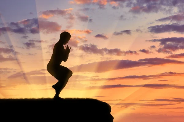 Silueta de un hombre practicando yoga — Foto de Stock