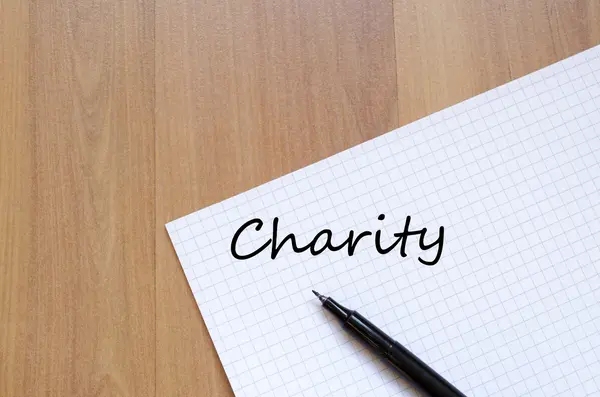 Wohltätigkeitsorganisation schreibt auf Notizbuch — Stockfoto
