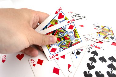 Elinde kartlarla oynuyor. 