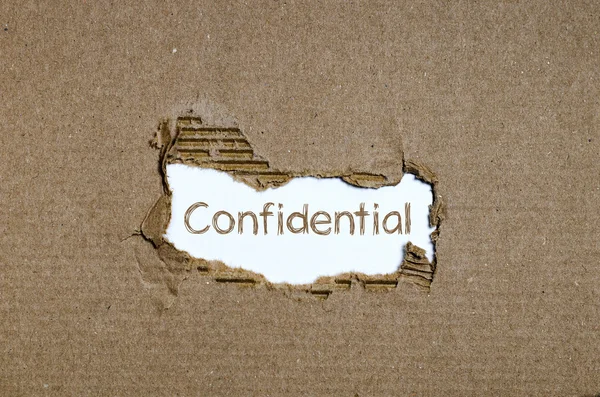 The word Confidential appearing behind torn paper. — Stock Photo, Image