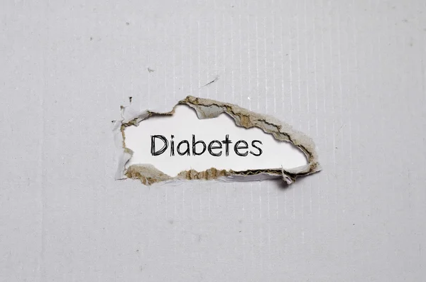 A palavra diabetes aparecendo atrás do papel rasgado . — Fotografia de Stock