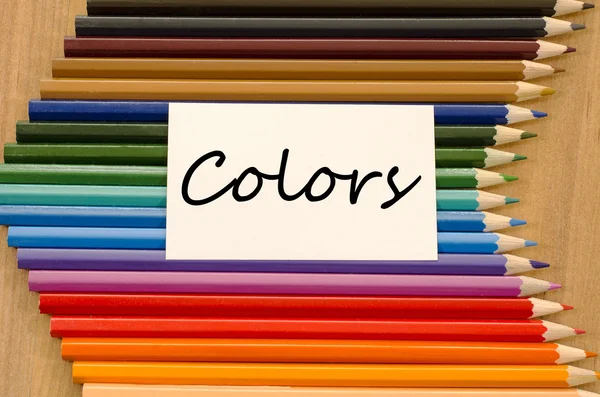 Livro branco em branco e lápis colorido sobre fundo de madeira — Fotografia de Stock
