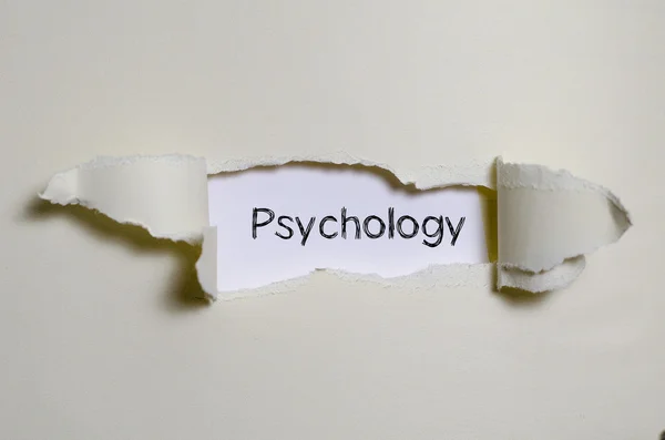 Ordet psykologi som syns bakom pappersrevor. — Stockfoto