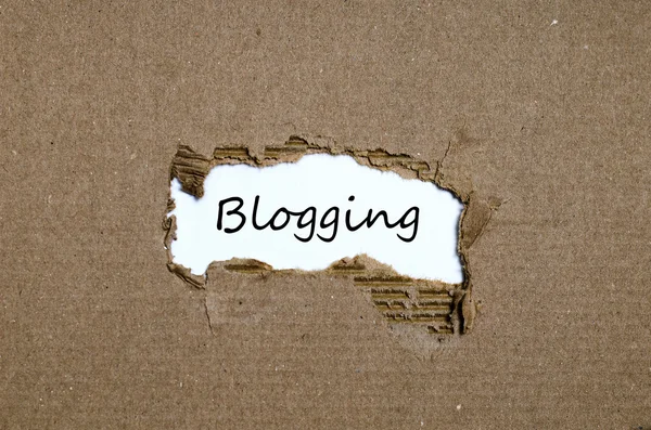 Słowo blogowanie pojawiające się za podartym papierem — Zdjęcie stockowe