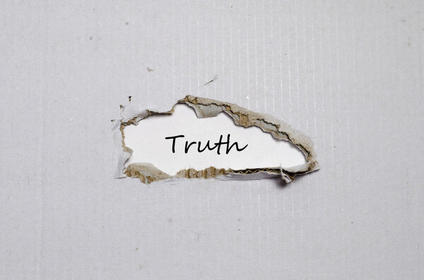 The word truth appearing behind torn paper