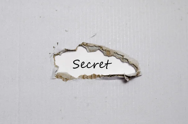 La palabra secreto que aparece detrás del papel roto — Foto de Stock