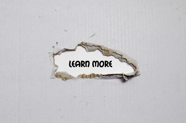 La palabra aprender más que aparece detrás del papel roto — Foto de Stock