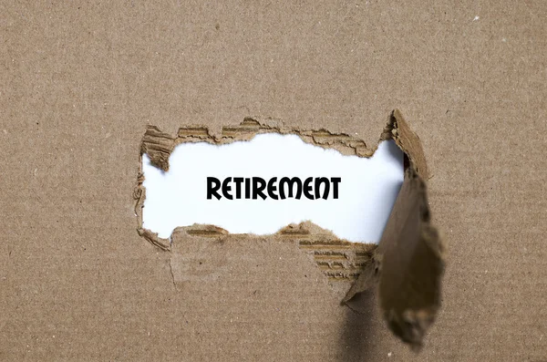 La parola pensionamento appare dietro carta strappata — Foto Stock