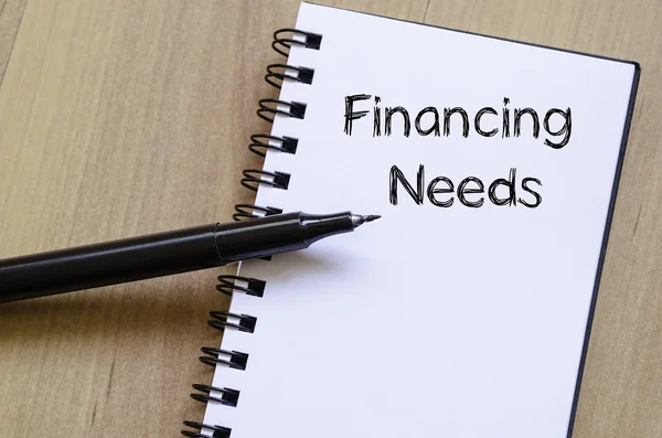 Necessidades de financiamento escrever no caderno — Fotografia de Stock