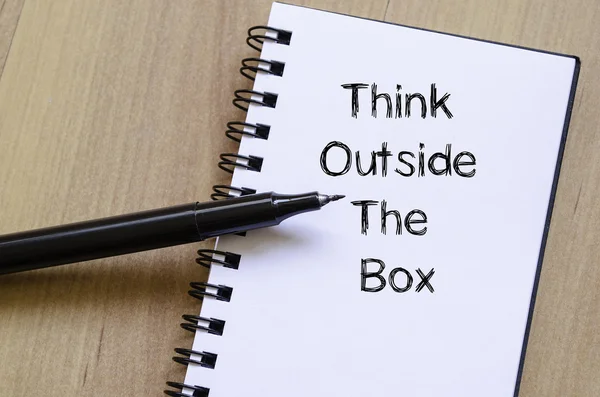 Piensa fuera de la caja escribe en el cuaderno — Foto de Stock
