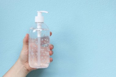 Kadın elinde bir şişe alkol jeli, antibakteriyel sabun dezenfektanı, enfeksiyon kapan Corona virüsünün (COVID-19) yayılmasını önlemek için% 70 oranında etanol bazlı temizleyici içerir, steril antiseptik.