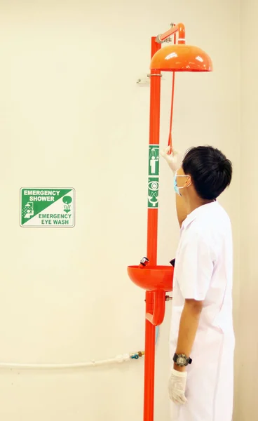 Eye wash station and Emergency shower testing by the scientist for flowing the water washing eyes, when touch with Acid or toxic chemical, safety first protection equipment in chemistry laboratory.