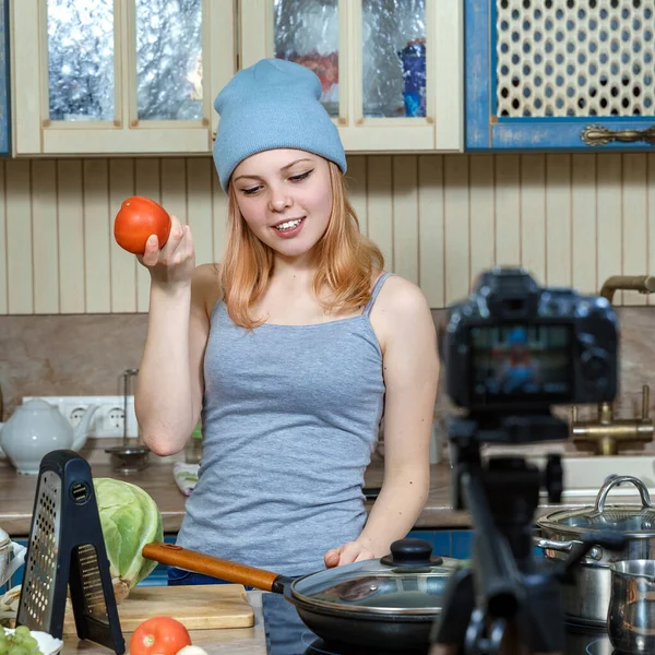 Girl teenager young food blogger prepares food, writes the recipe to the camera. Woman preparing delicious and healthy food at home, teenager\'s hobby