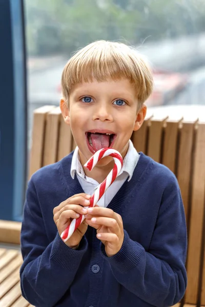 happy little boy eating a candy cane